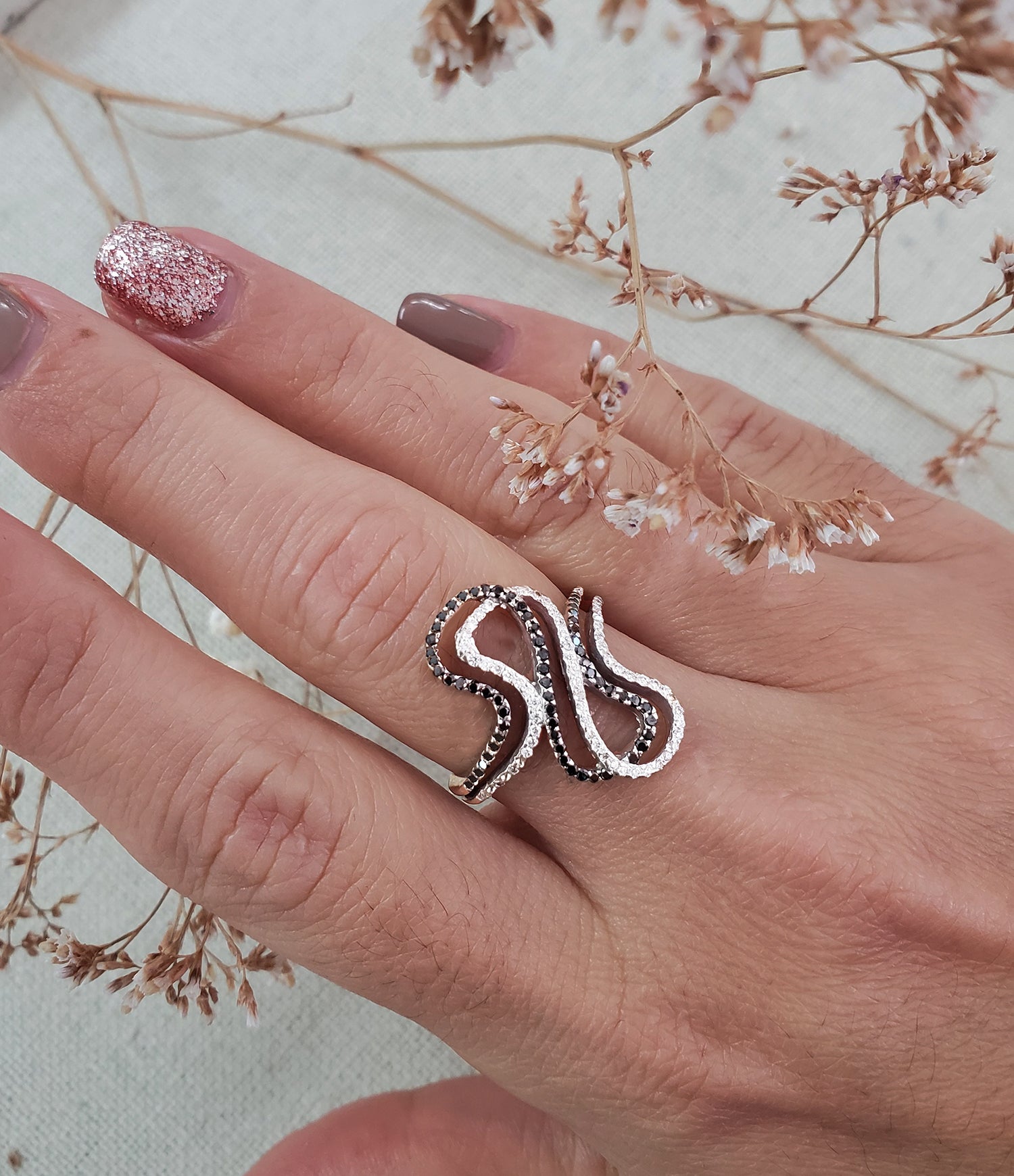 טבעת זהב לבן מפותלת יהלומים לבנים ושחורים