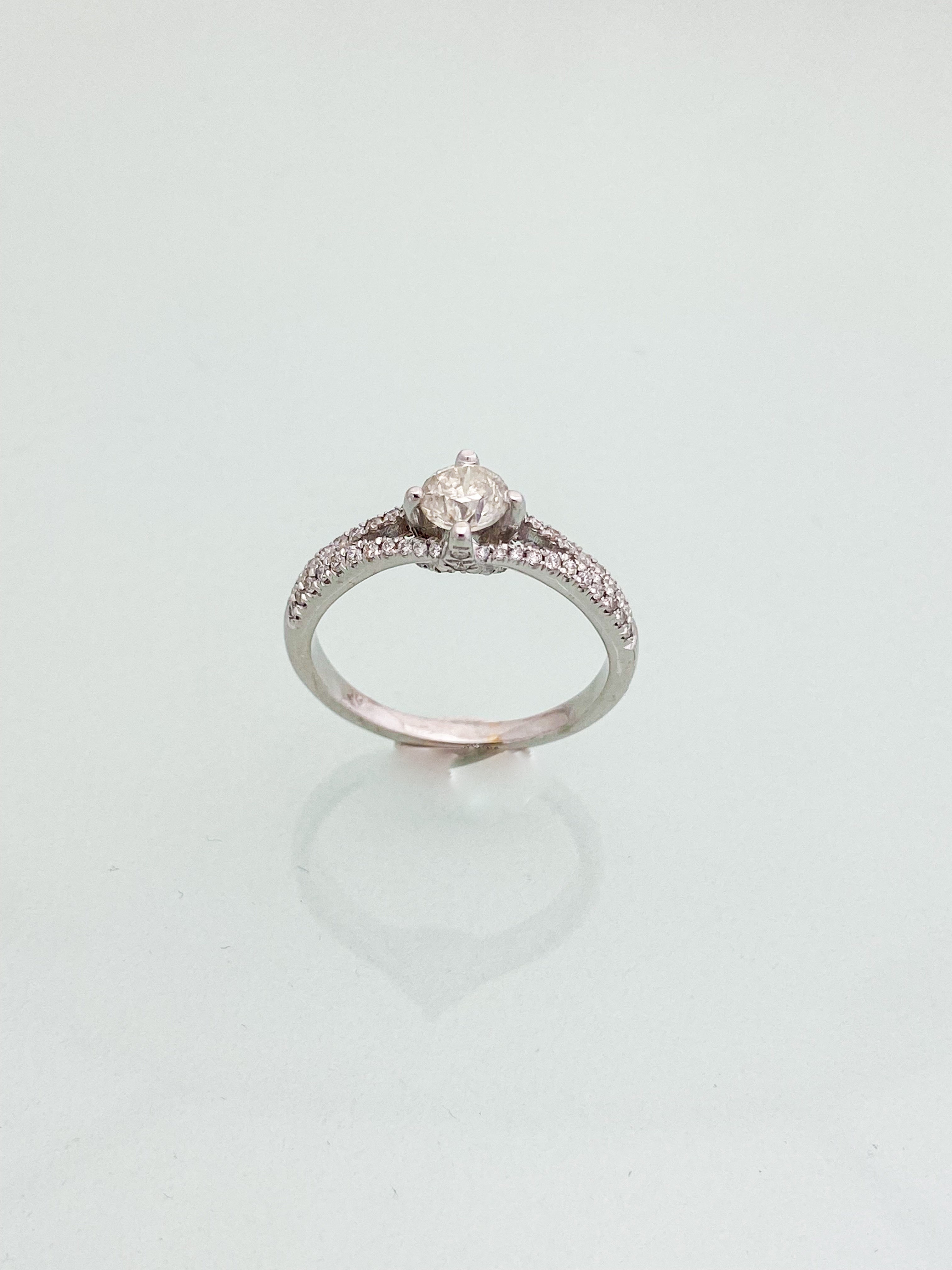 טבעת חישוק זהב לבן 14 קארט עם יהלום מרכזי ושיבוץ יהלומים בצדדים