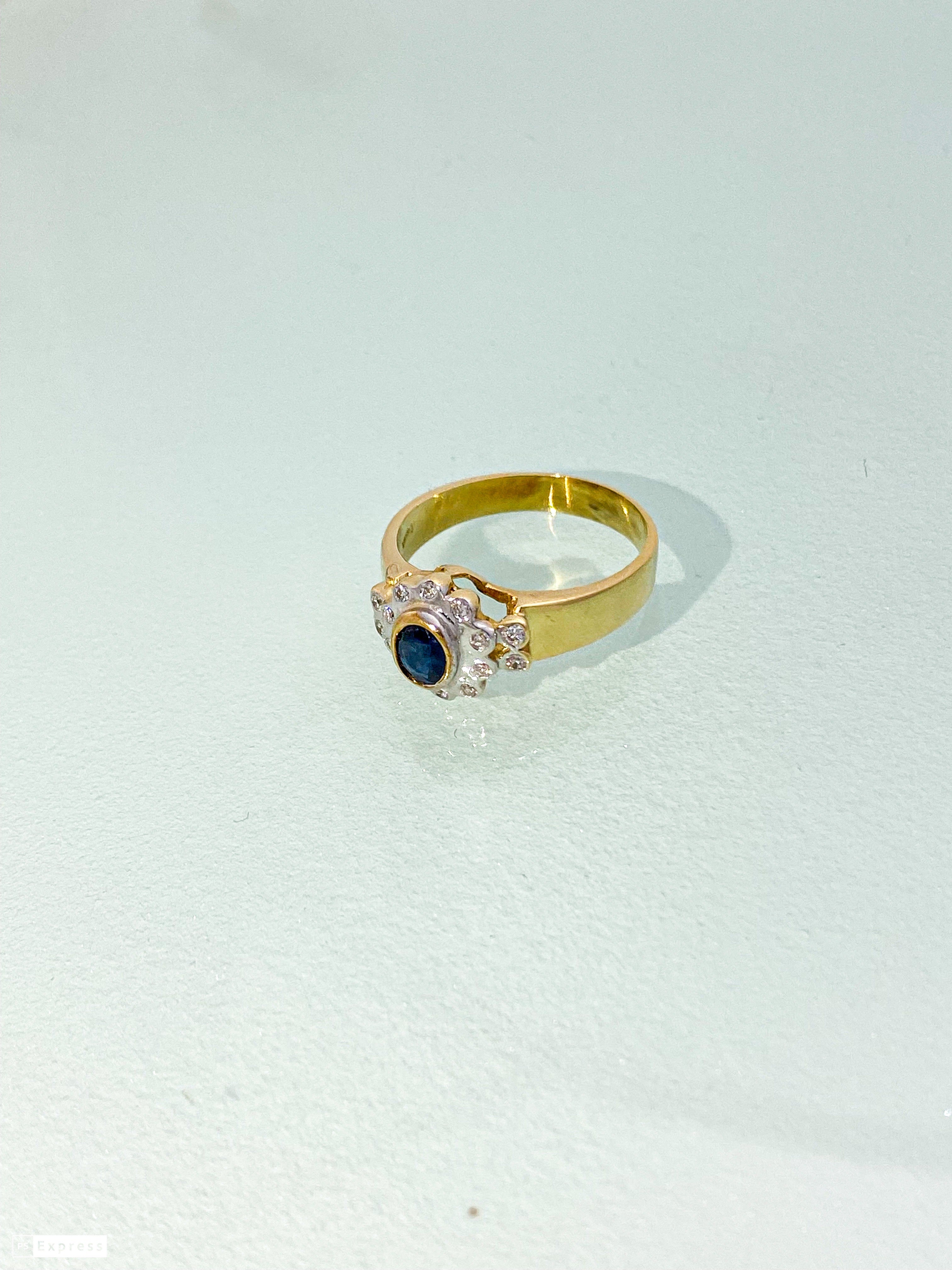 טבעת זהב צהוב 14 קארט עם פרח בזהב לבן אבן מרכזית ספיר ומסביב שיבוץ יהלומים