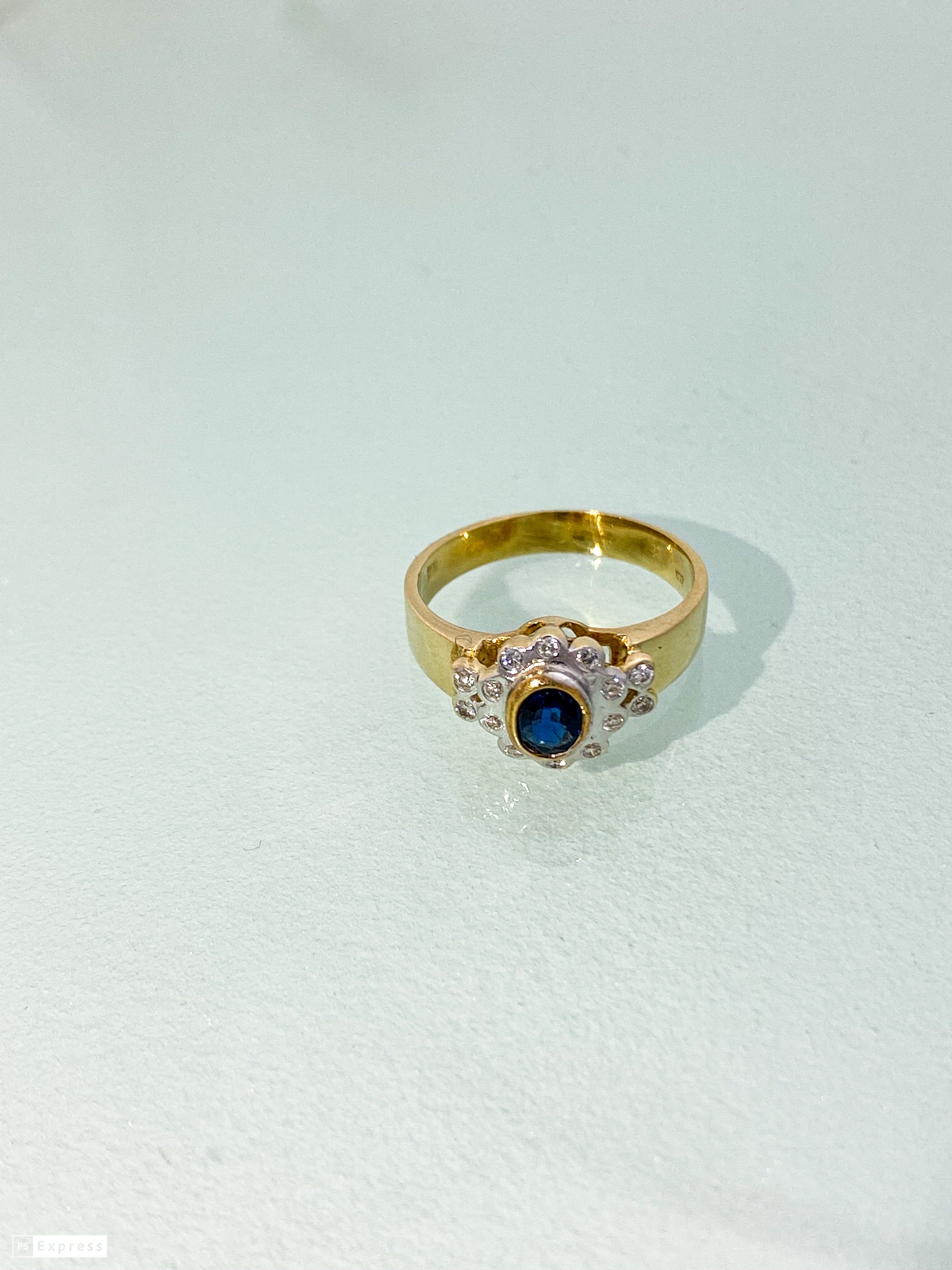 טבעת זהב צהוב 14 קארט עם פרח בזהב לבן אבן מרכזית ספיר ומסביב שיבוץ יהלומים